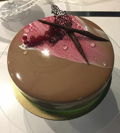 a cake with a pink and brown cake on top of a glass plate