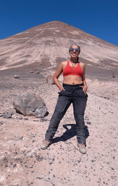 a woman in a red bra top standing in the desert cono de arita puna atacama salar salta