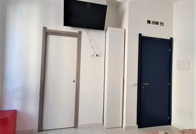 a bedroom with a television and a television
