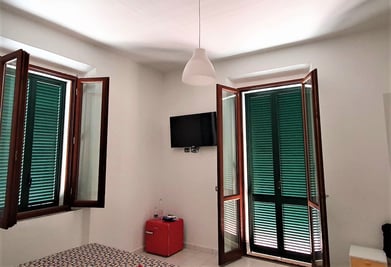 a room with a television and a red suitcase
