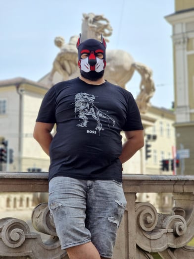 A man posing in a pup mask.