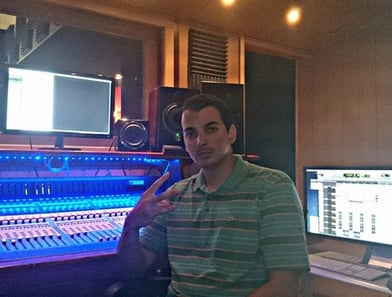 Rabzooz in a recording studio with a microphone and a computer