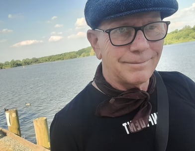 Rob Hamilton walking by a lake, smiling