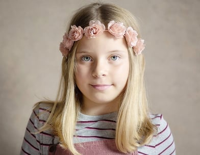 Photograph of a young girl wearing a flower band