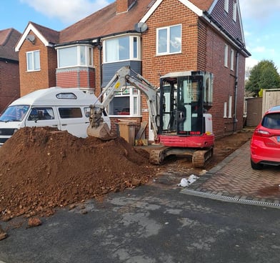 Digger picking up sand on a Dudley driveway during garden project