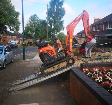 Mini digger being unloaded in Birmingham for groundwork services
