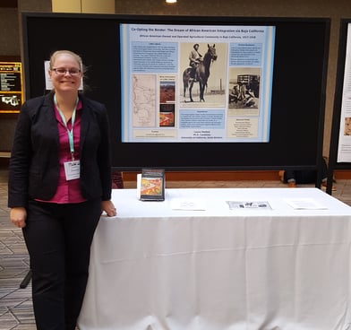 Laura Hooton, left, standing with Little Liberia poster, AHA 2017