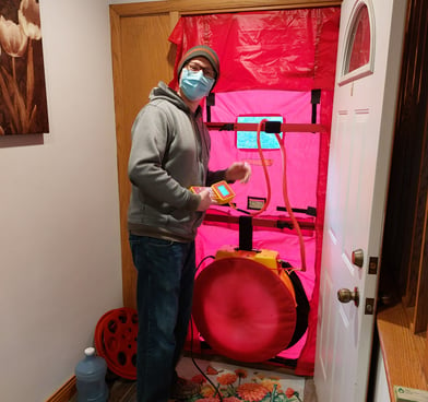 Energy assessor sets up the blower door for a home energy assessment.