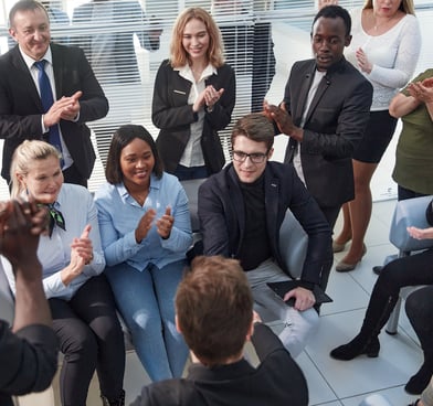 Diverse group of people smile applaud as spiritual teacher shares