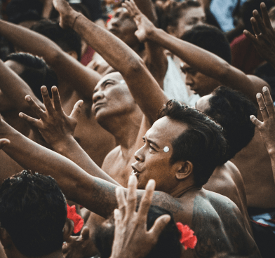 a man with a tattoo on his chest and hands up to his chest