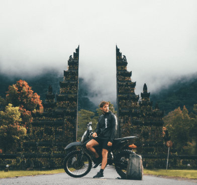 a man sitting on a motorcycle with a suitcase and luggage