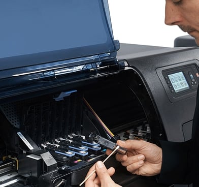 Man repairing an HP DesignJet Printer