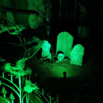 Glowing green backyard graveyard scene created by SweetAz Co. for a Halloween-themed house party in Redlands.