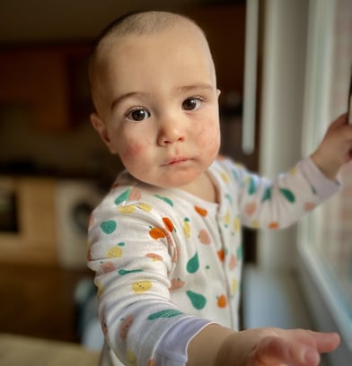 a baby is standing in front of a window