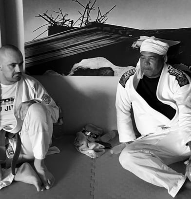 two men sitting on the mat