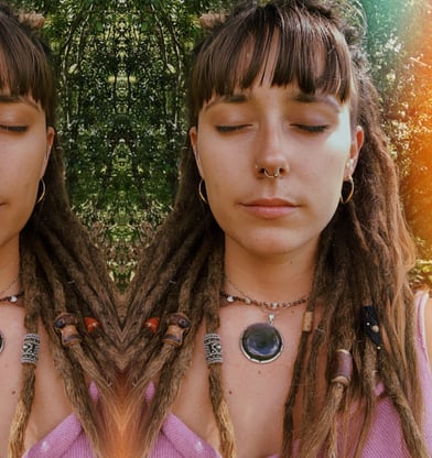 a woman with long dreadlocks and a pink shirt