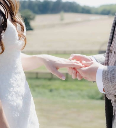 Groom placing a ring onto the finger of the bride