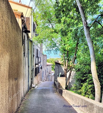 A narrow old alley with a row of old beautiful houses and cobblestone pavement in Europe