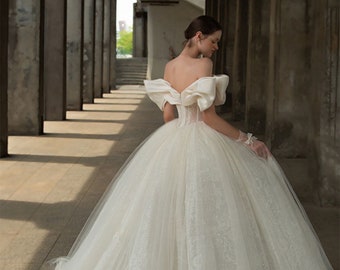 a woman in a white dress with a large bow tie