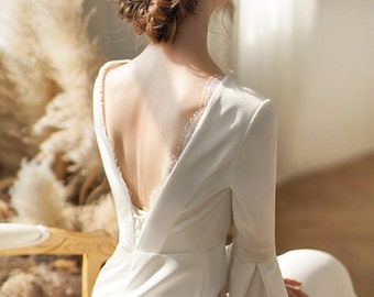 a woman in a white dress with an open back