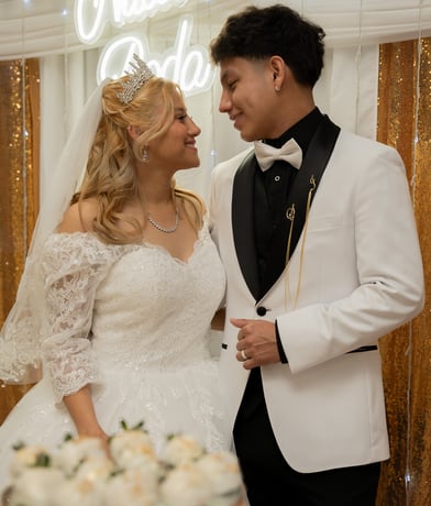 a bride and groom standing in front of a neon sign