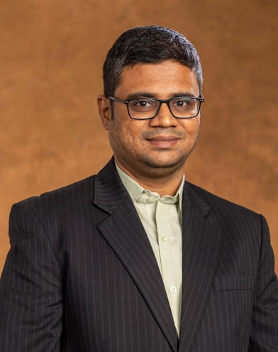 a man in a suit and glasses posing for a picture