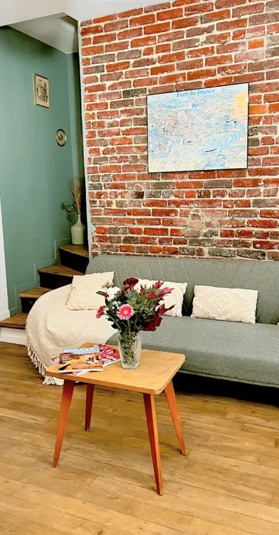 Relaxation area of the Maison des Voyageurs, featuring an industrial style with exposed brick walls 