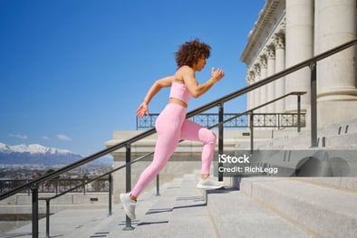 a woman running up stairs in a city