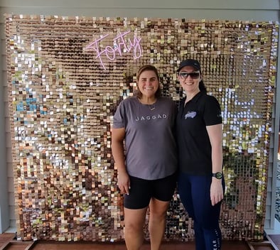 Linell and Carly in front of the rose gold shimmer wall and Forty neon sign in Brisbane.