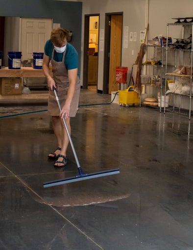 A student squeegeeing the floors of our clay studio.