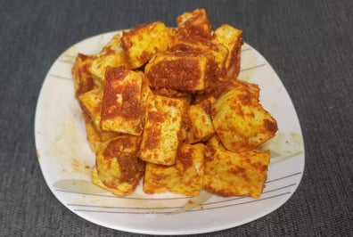 a pile of cottage cheese coated in spices