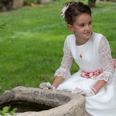 niña sentada con vestido de comunion 