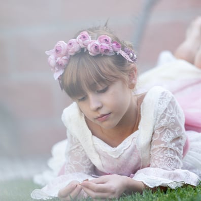 niña comunion tumbada mira sus manos pensativa    