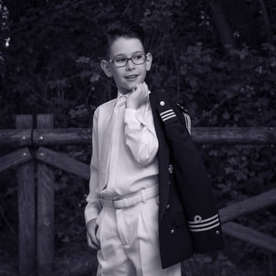 niño posa con su chaqueta de marinero al hombro  