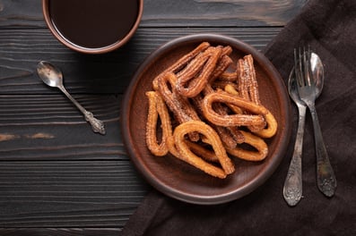 a bowl of churrons with a cup of coffee
