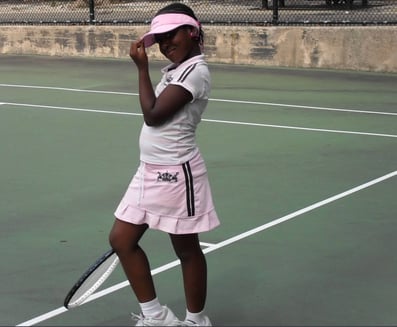 Image of Valicia Carmen at about 8 years old, on a tennis court in Brooklyn, NY