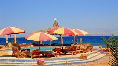 Bedouin star pool with umbrellas in front of the sea