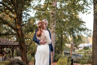 Husband and wife photographed in a forest on their wedding day