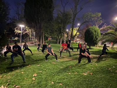 Esat Ataç leading a nighttime Tai Ji group session in Yoğurtçu Park, with students in 36 form.