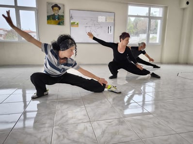 Members of the İzmir team practicing low stances indoors during a Tai Ji session.