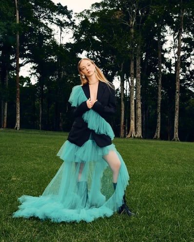 Full-body shot of model in a blue ruffle suit in a Bali forest, styled for a fashion editorial.