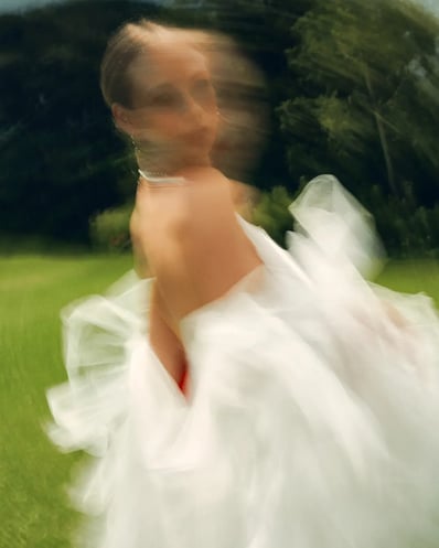 Portrait of model in white lace captured with slow shutter speed to create a motion blur effect.