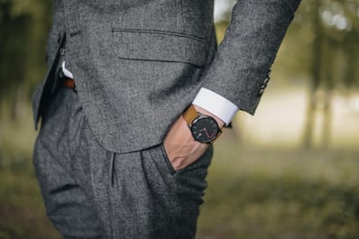 un homme en costume gris avec une montre