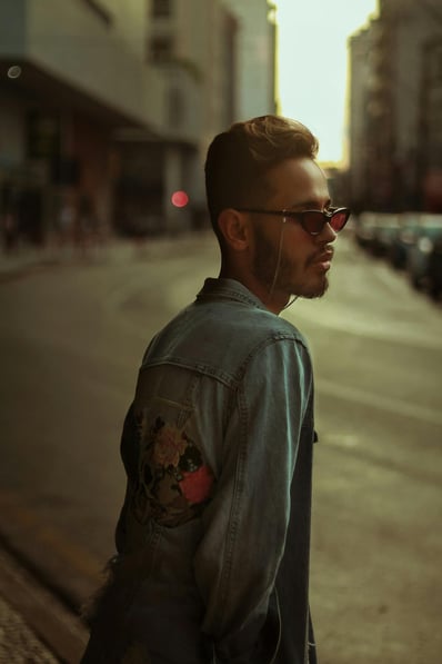 un homme qui porte une veste en jeans avec un patch dans le dos