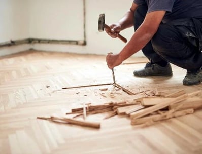 ouvrier qui casse le parquet au sol