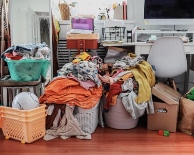 a messy desk surrounded by piles of clutter