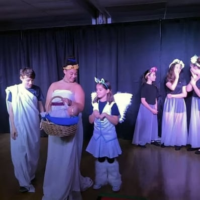 Childern and youth actors in a musical written by a teen playwright on stage.