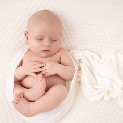Bébé qui dort enveloppé d'un wrap en rond
