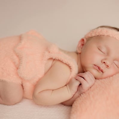 bébé qui dort avec ses petites mains contre sa t^ête
