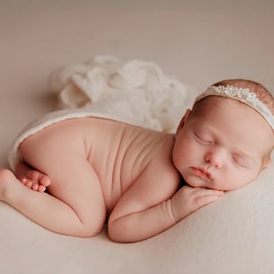 bébé en posing qui dort avec une grande douceur et on voit ses petits pieds